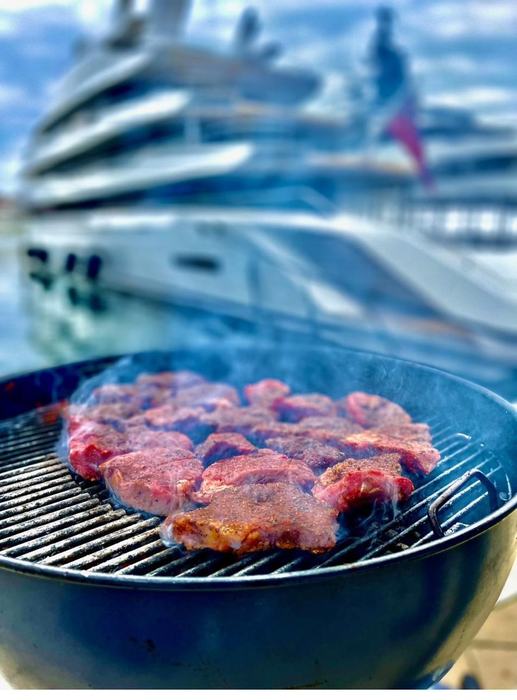 Grillen am Hafen mit Yacht im Hintergrund