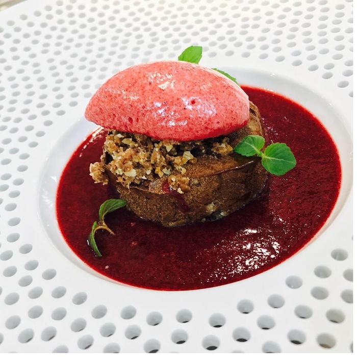 Rotes Sorbet-Dessert auf gepunktetem Teller